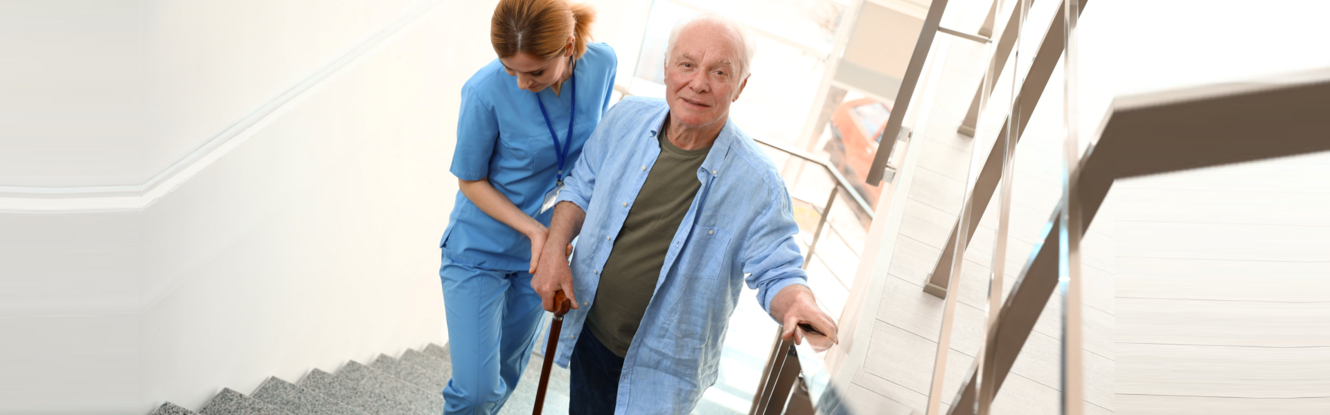 elderly going up the stairs while caregiver is supporting him