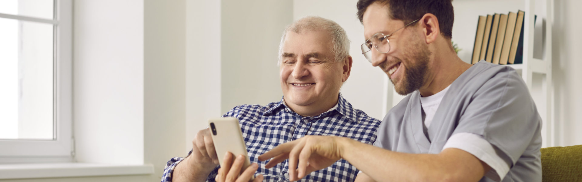 elderly and caregiver watching in their phone