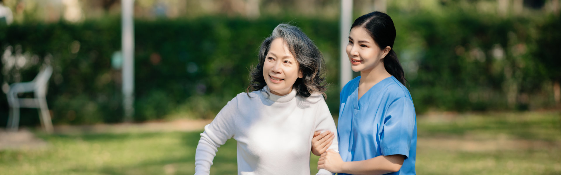 senior woman and caregiver walking at the backyard